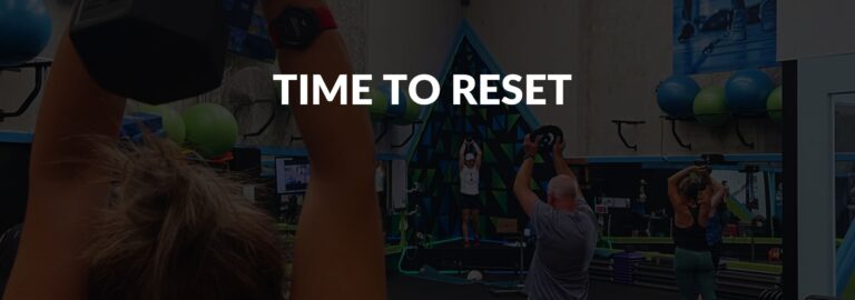 People exercising in a gym with "Time to Reset" text overlay, symbolizing restarting fitness after a break