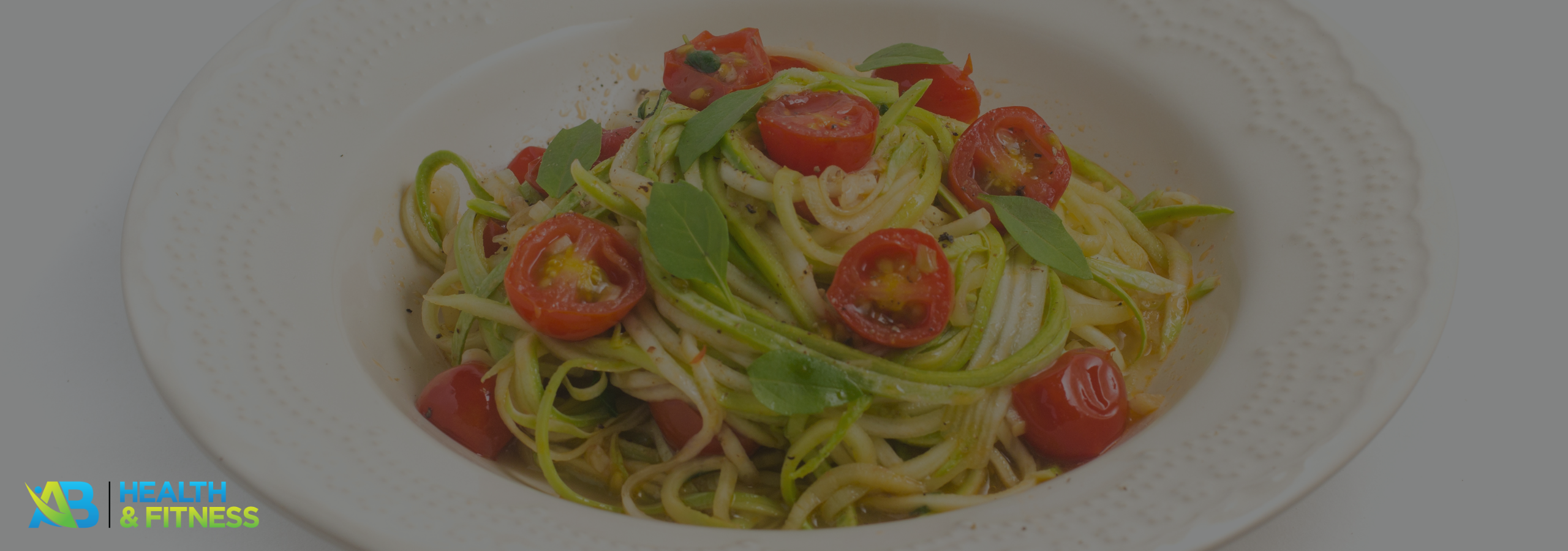Zucchini noodles with pesto and cherry tomatoes in a bowl
