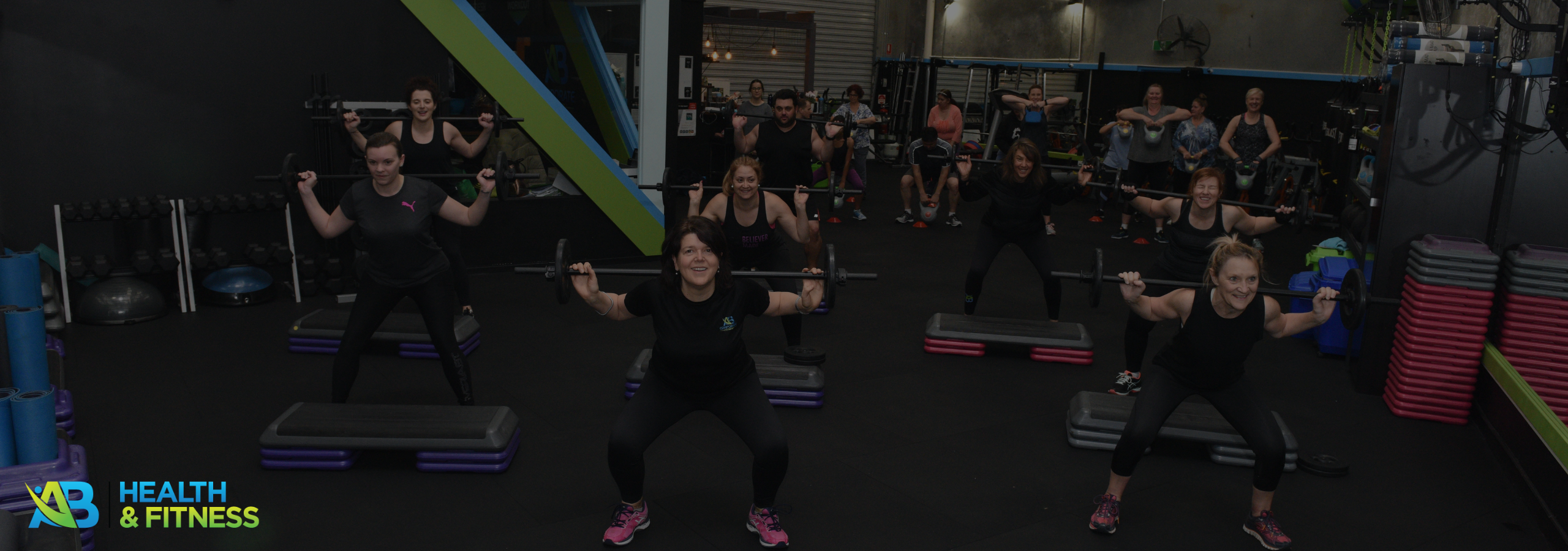 friendly female fitness coach guiding members through a workout session in an inclusive gym environment.